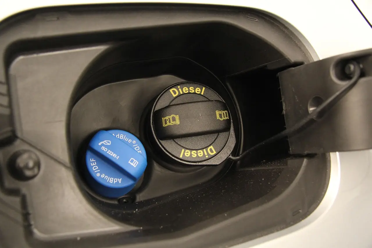 Blue AdBlue filler cap beside the black diesel filler cap on a vehicle